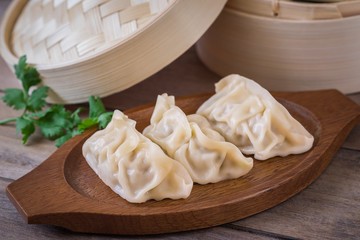 Steamed dumplings on wooden plate