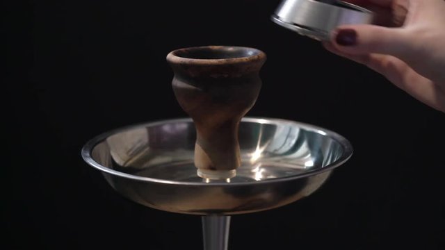 Woman preparing hookah bowl for smoking shisha
