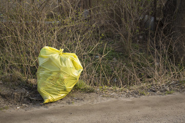 garbage bags stand near the road, pollution of nature