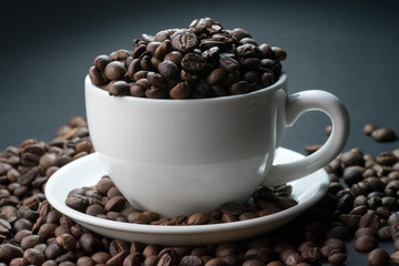 coffee in white cup and coffee beans are the background.