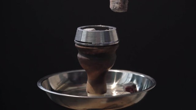 Man preparing hookah bowl and coald for smoking shisha