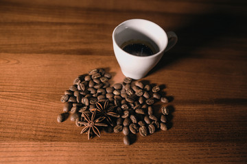 Coffee cup and coffee beans on wooden background.