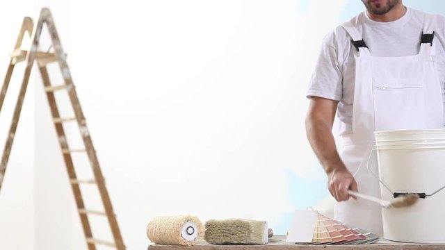 painter man at work with brush, wall painting concept, white copy space background