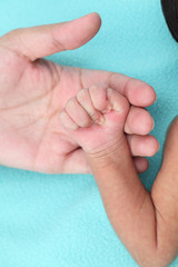 Obraz na płótnie Canvas Mother holding newborn baby's hand-New life care