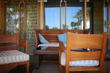 Street restaurant with dinner furnishing and reflection of palm trees on the glass doors