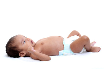 Playful newborn baby lying down in bed