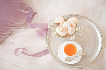 silver tray with cup of tea and macaroons top view.