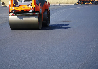 close up on compactor roller paving the asphalt road
