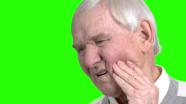 Close up old man massaging touching his cheek. Grandpa touching his cheeck because of teeth pain, close up, green hromakey backgorund.
