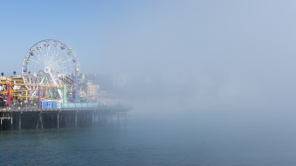 Sudden fog covering fast the Venice Beach towards the iconic ferris wheel from the famous Santa Monica Pier, Los Angeles, California, USA