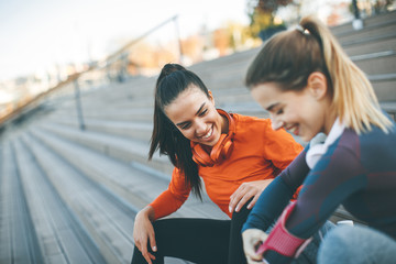 Two young women resting after doing sports outdoors