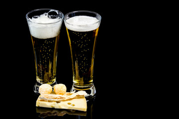 Glasses of fresh beer with cheese and cheese  spheres and kalmar