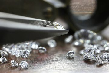brilliant cut diamond held by tweezers