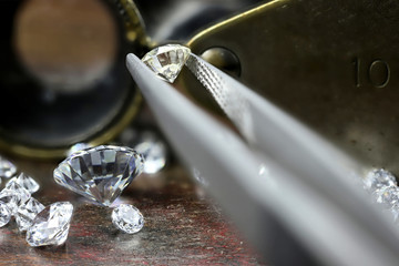 brilliant cut diamond held by tweezers