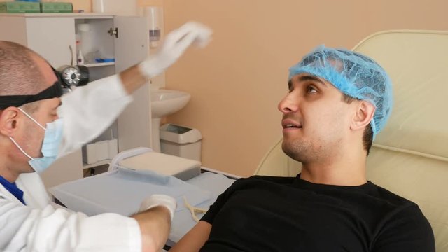 Man Having otolaryngologist Examination, doctor inspects a man's throat