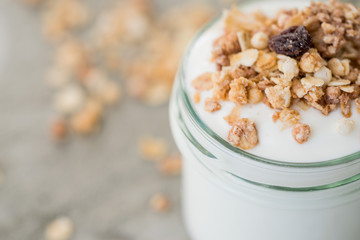 Yoghurt with granola made of oats, raisins, puffed rice, chocolate and dried bananas. Healthy breakfast for family.
