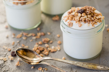 Yoghurt with granola made of oats, raisins, puffed rice, chocolate and dried bananas. Healthy breakfast for family.