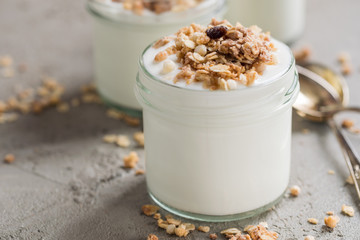 Yoghurt with granola made of oats, raisins, puffed rice, chocolate and dried bananas. Healthy breakfast for family.
