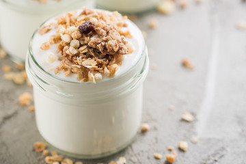 Yoghurt with granola made of oats, raisins, puffed rice, chocolate and dried bananas. Healthy breakfast for family.