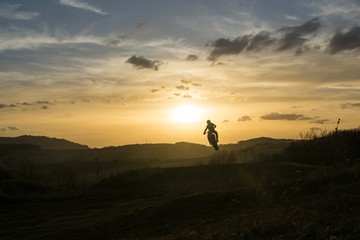 Obraz na płótnie Canvas Motorcyclist riding off road during sunset. Slovakia