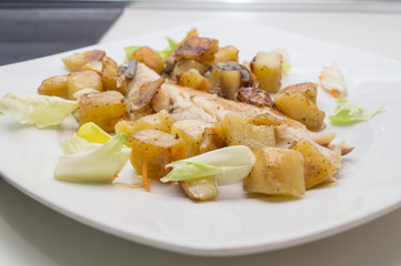 sea bass in the dish with potatoes and salad