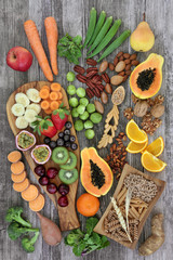 Food with high fibre content with fresh fruit and vegetables, nuts, grains and whole wheat pasta, super foods high in antioxidants, anthocyanins and vitamins. Rustic background top view.