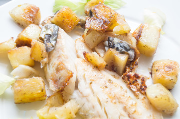 sea bass in the dish with potatoes and salad