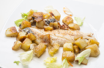 sea bass in the dish with potatoes and salad