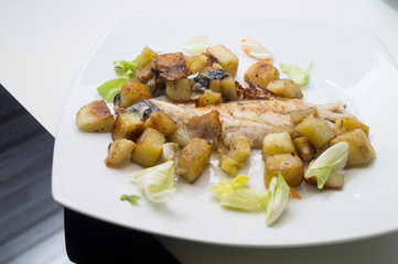 sea bass in the dish with potatoes and salad