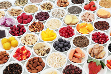 Health food for a healthy heart concept with super food of fish, fruit, vegetables, legumes, nuts, seeds, grains, cereals with herbs and spice used in alternative herbal medicine. 