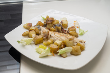 sea bass in the dish with potatoes and salad