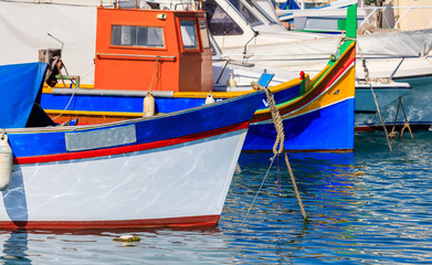 Fototapeta na wymiar Marsaxlokk fishermen village in Malta. Traditional colorful boats at the port of Marsaxlokk. Closeup view