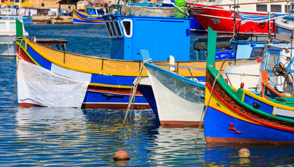 Fototapeta na wymiar Marsaxlokk fishermen village in Malta. Traditional colorful boats at the port of Marsaxlokk. Closeup view
