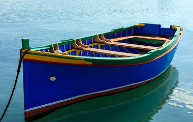 Fototapeta na wymiar Traditional colorful boat luzzu at the port of Marsaxlokk, Malta. Closeup view