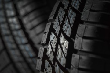 New and unused car tires against dark background