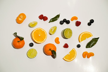 Fruits on white background isolated: orange, mandarin, lime, bluberry and raspberry