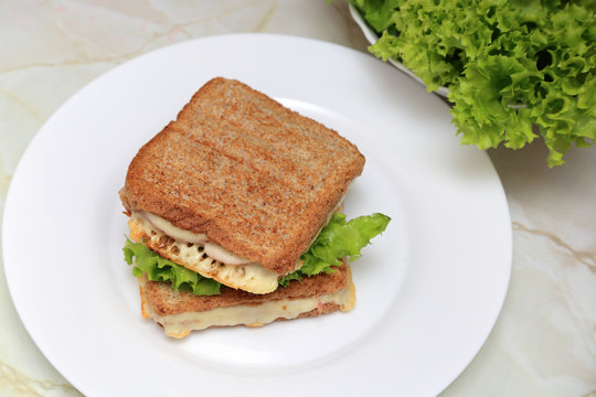 Posiłek z tost&oacute;w robionych w tosterze, sałaty, papryki, kiełbasy szynkowej i herbaty owocowej.