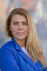 Young elegant business woman in blue jacket.