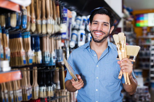 buyer holding various paint brushes