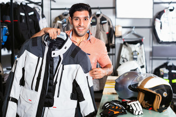 Fototapeta na wymiar Male customer is demonstrating modern jacket that he choose