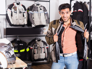 Happy man is trying up new jacket for motorbike
