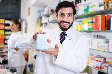 Pharmacist holding medicines in drugstore