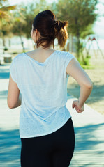Female in black T-shirt is jogging her back