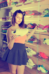 Young sportswoman looking professional shoes