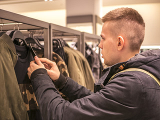 portrait of man picking up clothes in the store