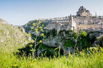 Horizontal View of the Church of Peter and Paul Saints on the Background of the Caves of the Gravina of Matera on Blue Sky Background. Matera, South of Italy