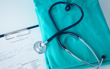 Stethoscope on a table with medical uniform