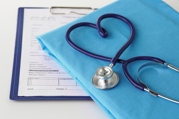 Stethoscope on a table with medical uniform