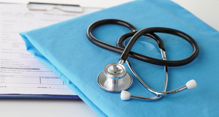 Stethoscope on a table with medical uniform