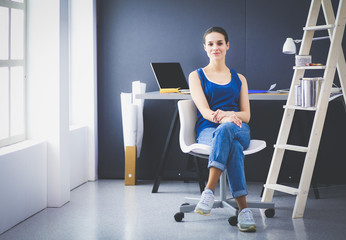 Young woman sitting on the desk in office